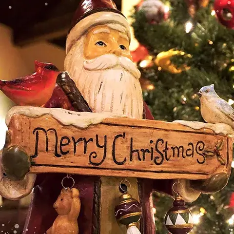 A Santa statue holding a Merry Christmas sign