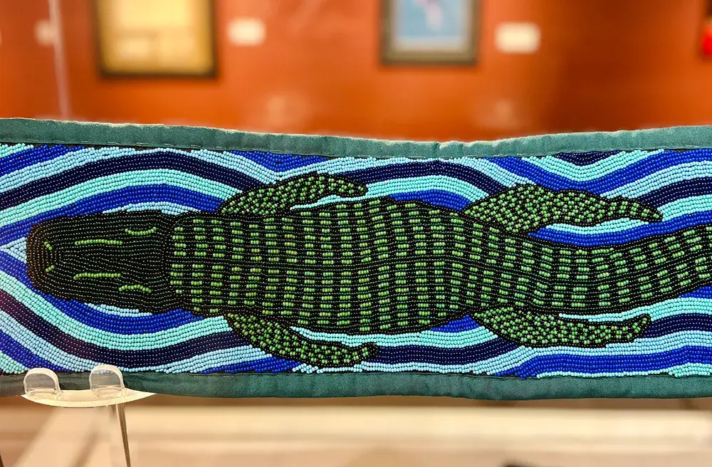 Brian Zapeda (Florida Seminole) – Alligator Sash Cloth, yarn and size 10 and 11 seed beads<br />
2023