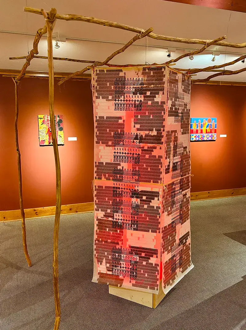 Tony A. Tiger (Oklahoma Seminole/Muscogee/Sac & Fox) – Community Arbor: Time and Place<br />
Young pecan trees, ink, printed mulberry paper, copper wire, artificial sinew, LED light, wax<br />
2025